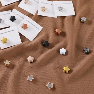 Primo piano di spille magnetiche in metallo a forma di stella per hijab con finiture.