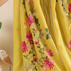 Detailed view of women's lightweight floral embroidered yellow scarf cotton linen shawl.