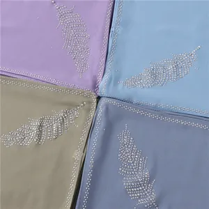 Gedetailleerd uitzicht van chiffon hijab sjaal met fonkelend strass verenpatroon en elegante rand.