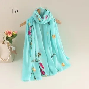 Lightweight blue embroidered scarf detail, soft breathable material with floral patterns.