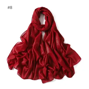 Red glitter chiffon long scarf hijab detail view, elegant shimmering Muslim head wrap.