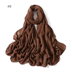 Close-up detail of shimmering brown chiffon long scarf showing sparkly texture and fine edge finish.