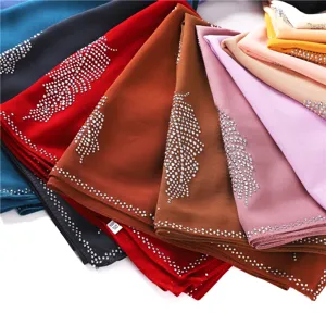 Detailopname van meerkleurige chiffon strass hijab vierkante sjaals netjes gelaagd.