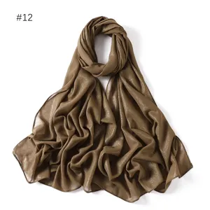 Brown sparkly chiffon hijab detail, beautiful shimmer long scarf fabric close-up display.