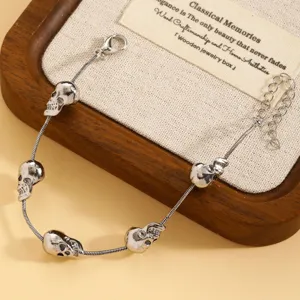 Close-up detail van gotische punk zilverkleurige metalen schedel bedelarmband ketting.