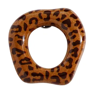 Gros plan détaillé de la broche porte-lunettes léopard géométrique, belle surface en résine brillante.