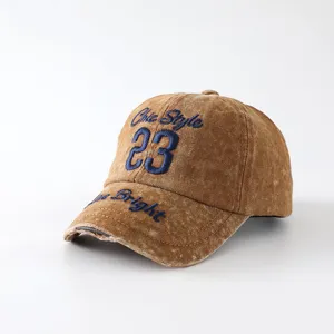 Vintage distressed washed baseball cap detail view, brown cotton fabric with blue embroidery.