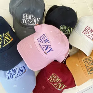 Detailed close-up shot of multi-color distressed baseball caps with embroidered letter patches.
