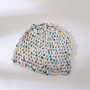 Gedetailleerde close-up van handgemaakte gehaakte kinder muts met kleurrijke pailletten.