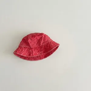 Detailed view of children's washed cotton red bucket hat showing fabric texture.