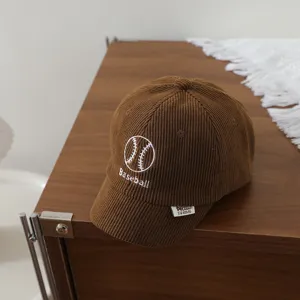 Brown corduroy baby baseball cap detail, featuring front embroidery and side label.