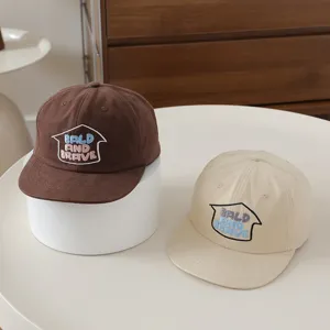 Detailed view of kids flat brim baseball caps in brown and beige with stylish front embroidery.