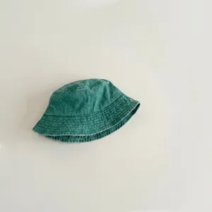 Detail shot of a green washed cotton bucket hat, showing fabric texture and brim design closely.