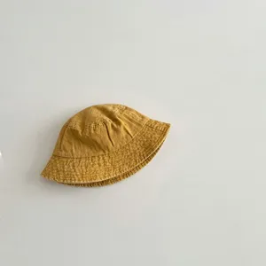 Close up view of kids mustard yellow washed cotton bucket hat showing soft fabric texture