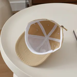 Detailed view of the kids beige baseball cap interior lining and clean stitching craftsmanship.