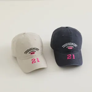 Primer plano detallado de gorras de béisbol bordadas para niños en color beige y gris oscuro.