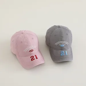 Vista detallada de gorras de béisbol de algodón bordado en rosa y gris, perfectas para niños.