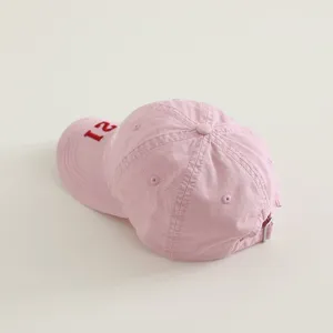Vista detallada de la gorra de béisbol rosa para niños con el número 21 bordado.