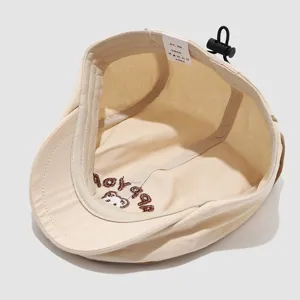 Kids beige melon cap interior detail showing size label and cute bear embroidery lining.