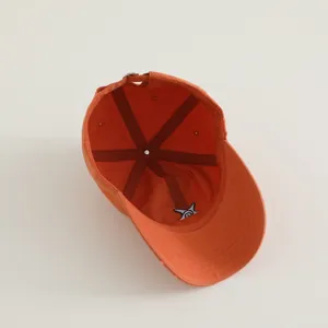 Orange kids baseball cap interior detail view, simple cute embroidered design, casual sun hat.