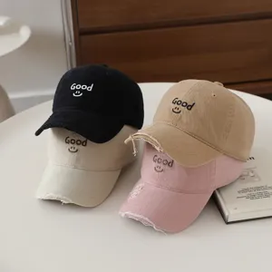 Close up of distressed kids baseball caps featuring cute Good embroidery and sweet smiley face.