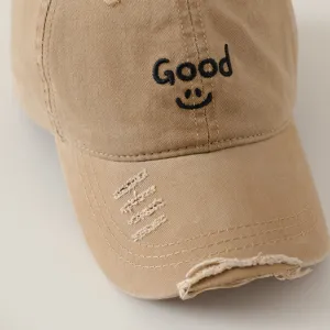 Distressed khaki baseball cap with Good letter embroidery and cool smiley face design.