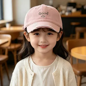 Close-up detail of the kids pink baseball cap featuring Good embroidery and distressed brim.