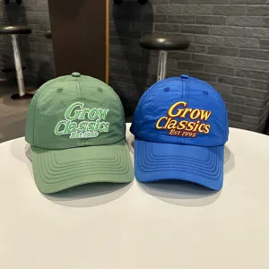 Nahaufnahme von Sommer-Baseballcaps für Kinder in Grün und Blau mit feiner Stickerei.