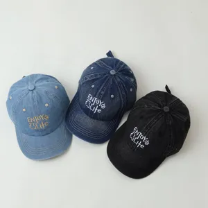 Children denim baseball cap detail view, showing three colors with embroidered text.