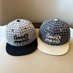 Detalle en primer plano de gorra de béisbol de cuadros para niños con texto bordado.