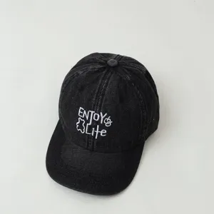 Kids washed denim baseball cap detail view, trendy embroidered letter design, curved brim.