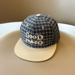 Primer plano detallado de la gorra de cuadros para niños con visera plana y lindo bordado.