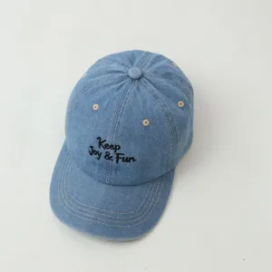 Close-up of light blue denim kids baseball cap featuring fine embroidery and soft fabric texture.