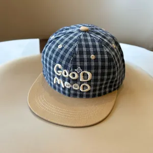 Vista detallada de la gorra de béisbol de cuadros para niños con bordado blanco.