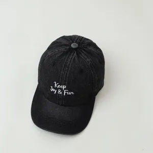 Classic dark denim children's baseball cap close-up showcasing neat white embroidery detail.
