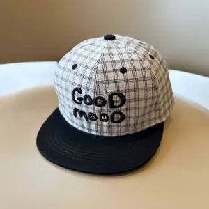 Primer plano detalle de gorra de cuadros para ninos con bordado y visera plana estilo.