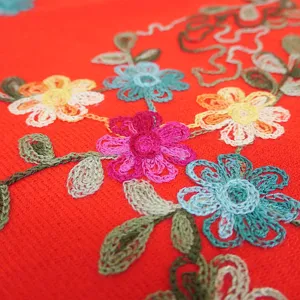 Detailed shot of winter embroidered floral scarf, warm orange cashmere-feel shawl.