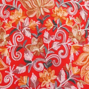 Detailed view of embroidered floral pattern on red winter cashmere feel warm scarf shawl.