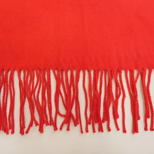 Detailed close-up view of the soft red imitation cashmere scarf with textured fringe.