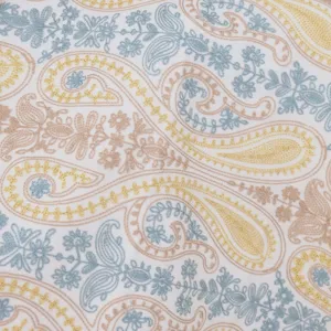 Close-up detail shot of luxury paisley cashmere scarf fabric featuring metallic gold embroidery.