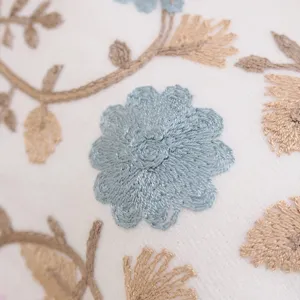 Detailed close-up view of elegant floral embroidery on soft cashmere-feel fabric texture.