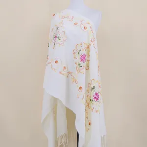 Detail of white ethnic embroidered cashmere-feel shawl scarf with floral totem and tassels.