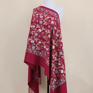 Detailed view of the red embroidered cashmere-feel shawl with exquisite floral and leaf patterns.