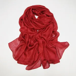 Soft solid color red scarf detail showing smooth fabric texture and elegant drape style.