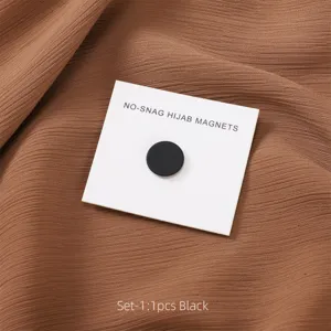 Detailansicht des schwarzen runden Hijab-Magneten auf braunem Stoff, starker Schal-Clip.
