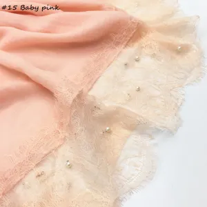 Katoenen linnen sjaaldetail met elegante kantrand en delicate parelversieringen.