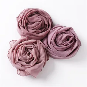 Detailansicht des rosenformig gefalteten Chiffon Kopftuchs in Staubrosa, weiche Stofftextur.