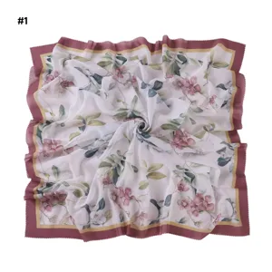 Detail shot of a large floral square scarf with elegant wavy cut edges and pink border.