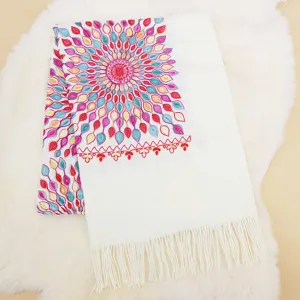 Detailed view of white cashmere feel women shawl scarf featuring colorful floral embroidery.