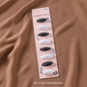 Detailed view of the 8pcs black and white scarf safety pins set, practical anti-exposure hijab clips.
